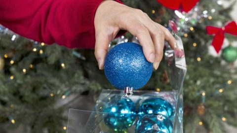 A woman putting away Christmas ornaments - Featured image for 