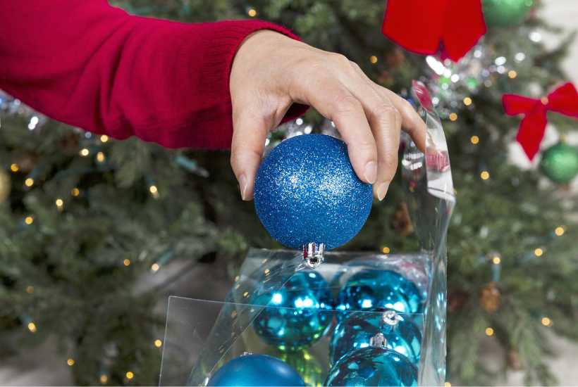 A woman putting away Christmas ornaments - Featured image for "Holiday storage solutions" blog post.